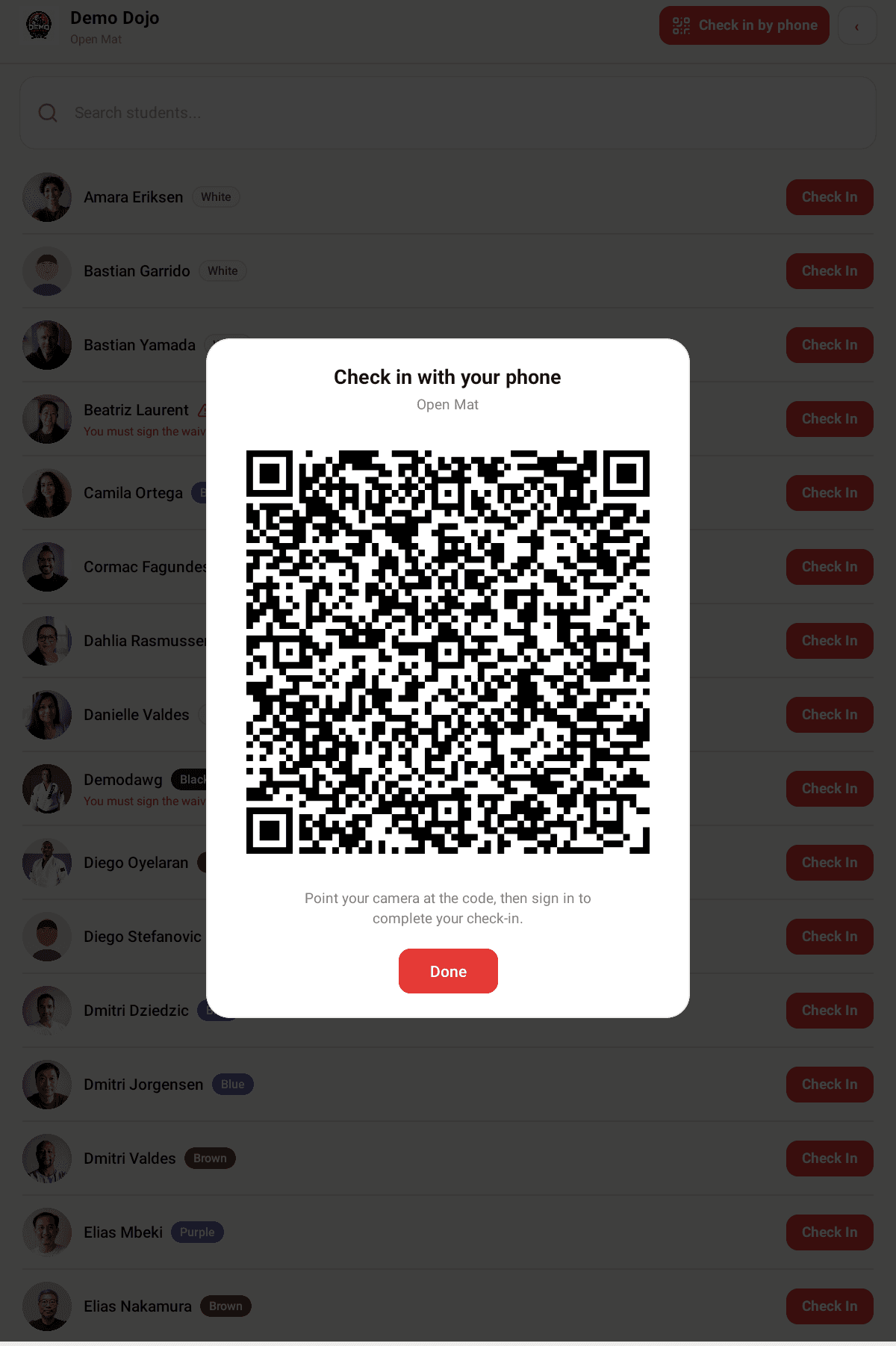 The kiosk displaying a large QR code headed Check in with your phone, over the class roster.